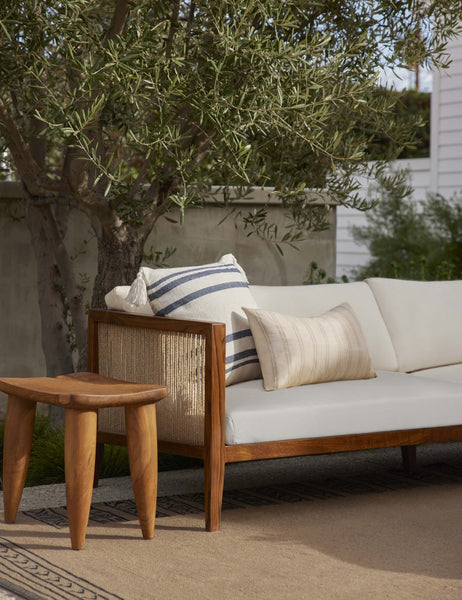 #color::slate | The Fez slate and white indoor and outdoor throw pillow sits on a ivory sofa in an outdoor space on a brown rug