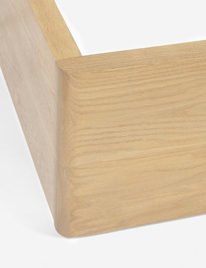 The corner of the wooden-base on the Nia mushroom brown linen bed
